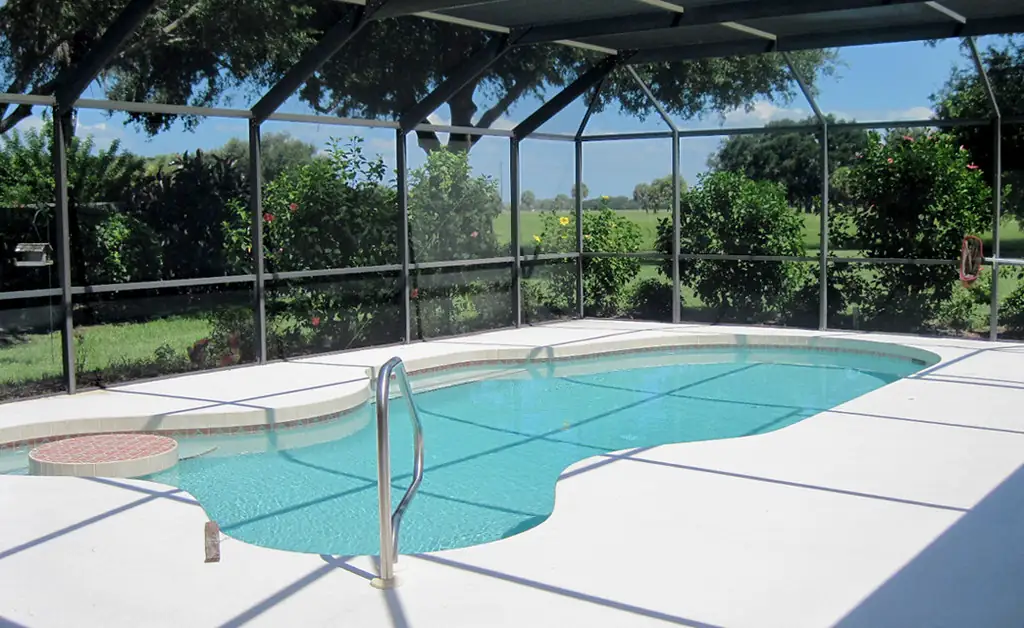 Technician rolling new screen into a pool cage panel frame in Tampa Bay